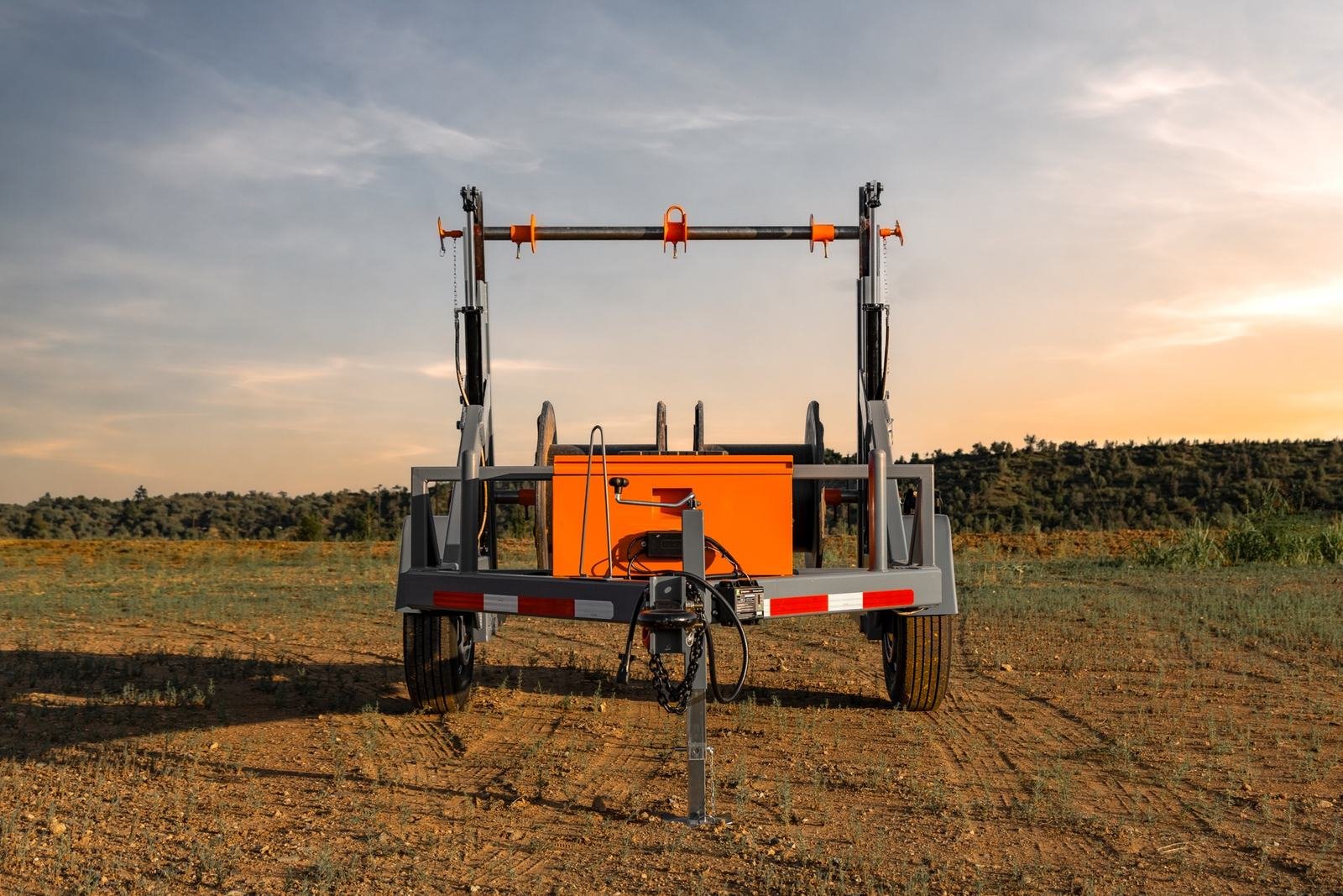 Front view of a reel trailer showing the steel reel bar and battery enclosure
