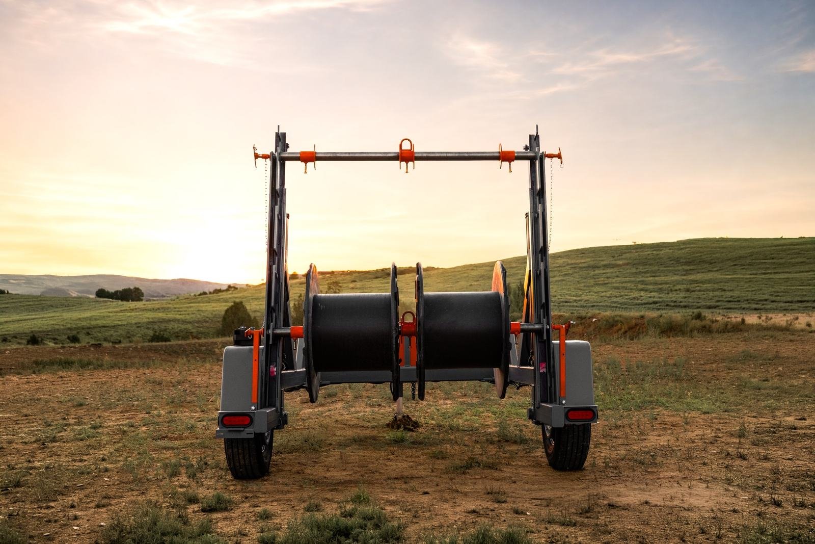 Rear view of a reel trailer with cable reels loaded between the stanchions